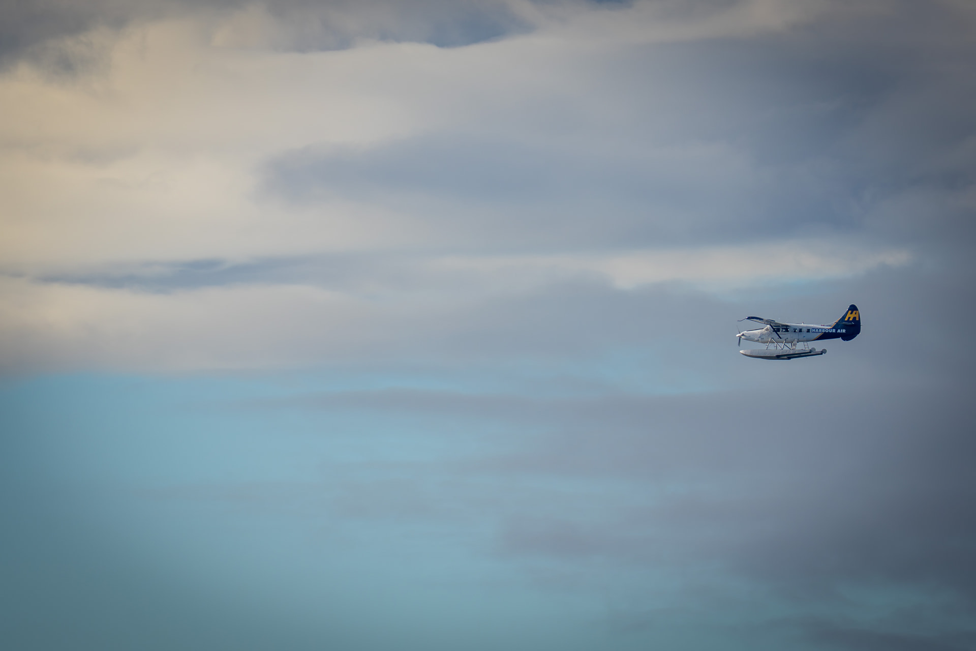 Wasserflugzeug von Harbour Air fliegt unter dunklen Wolken über Victoria