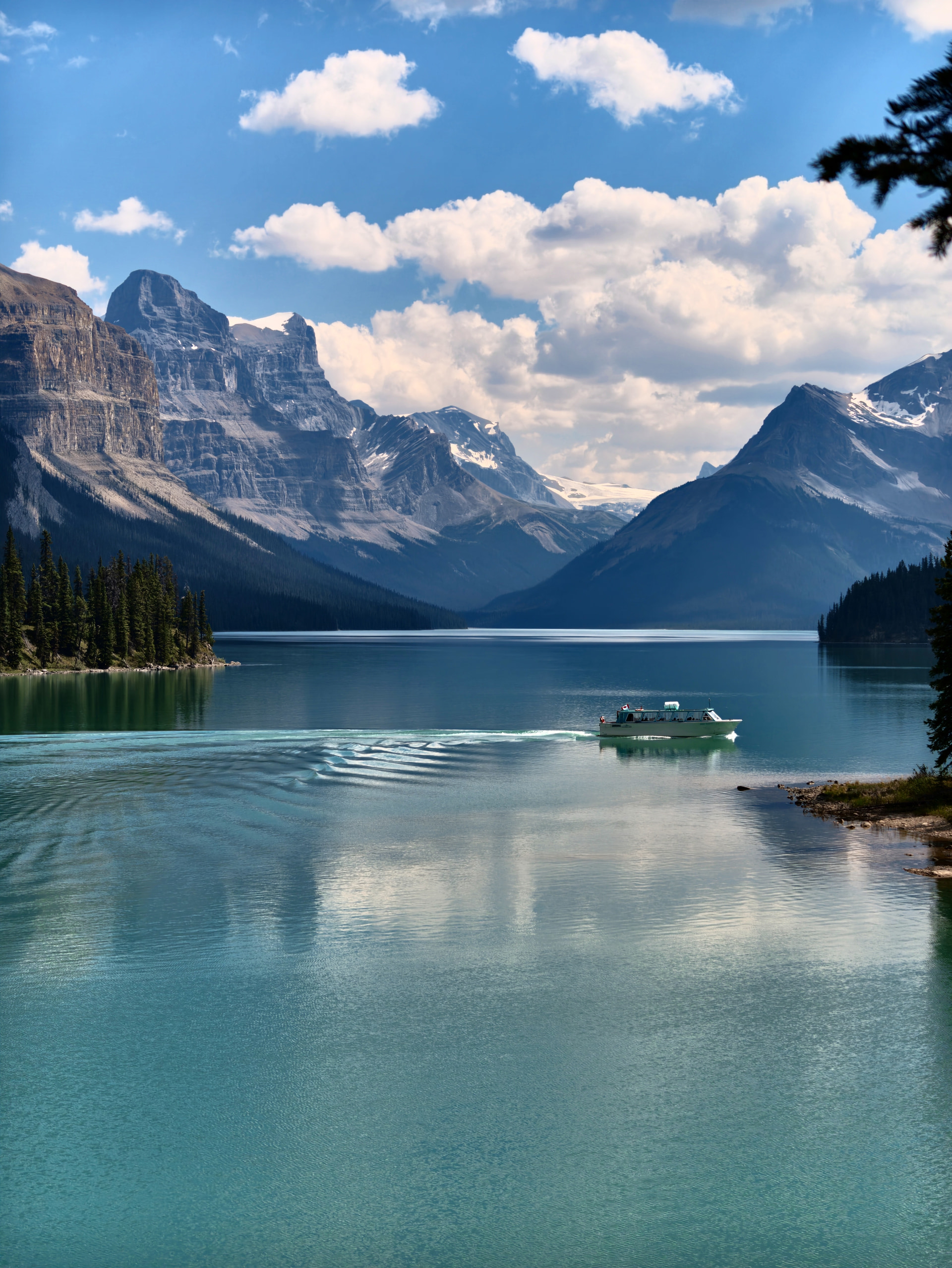 Ausflugsboot fährt von Spirit Island über den Maligne Lake davon