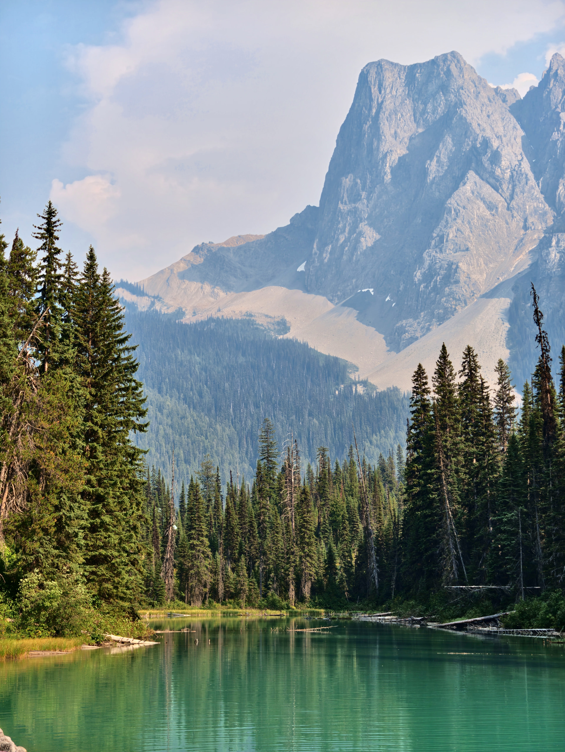 Emerald Lake mit bewaldetem Ufer und Mount Burgess im Waldbranddunst